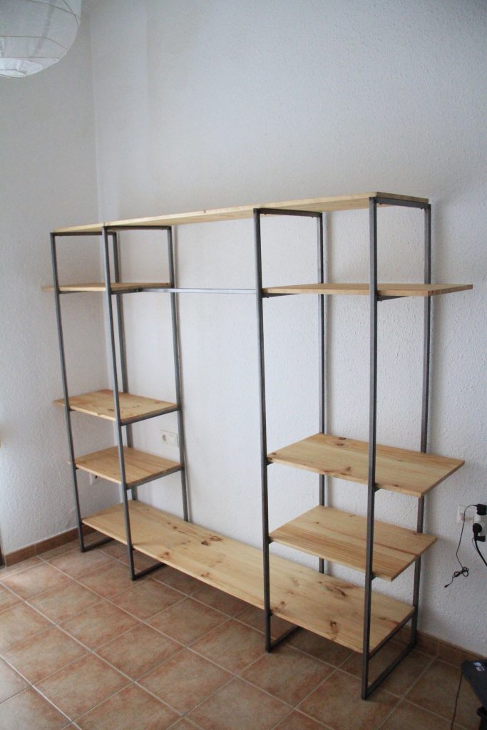 Estantería abierta con baldas de madera y bastidores metálicos.
