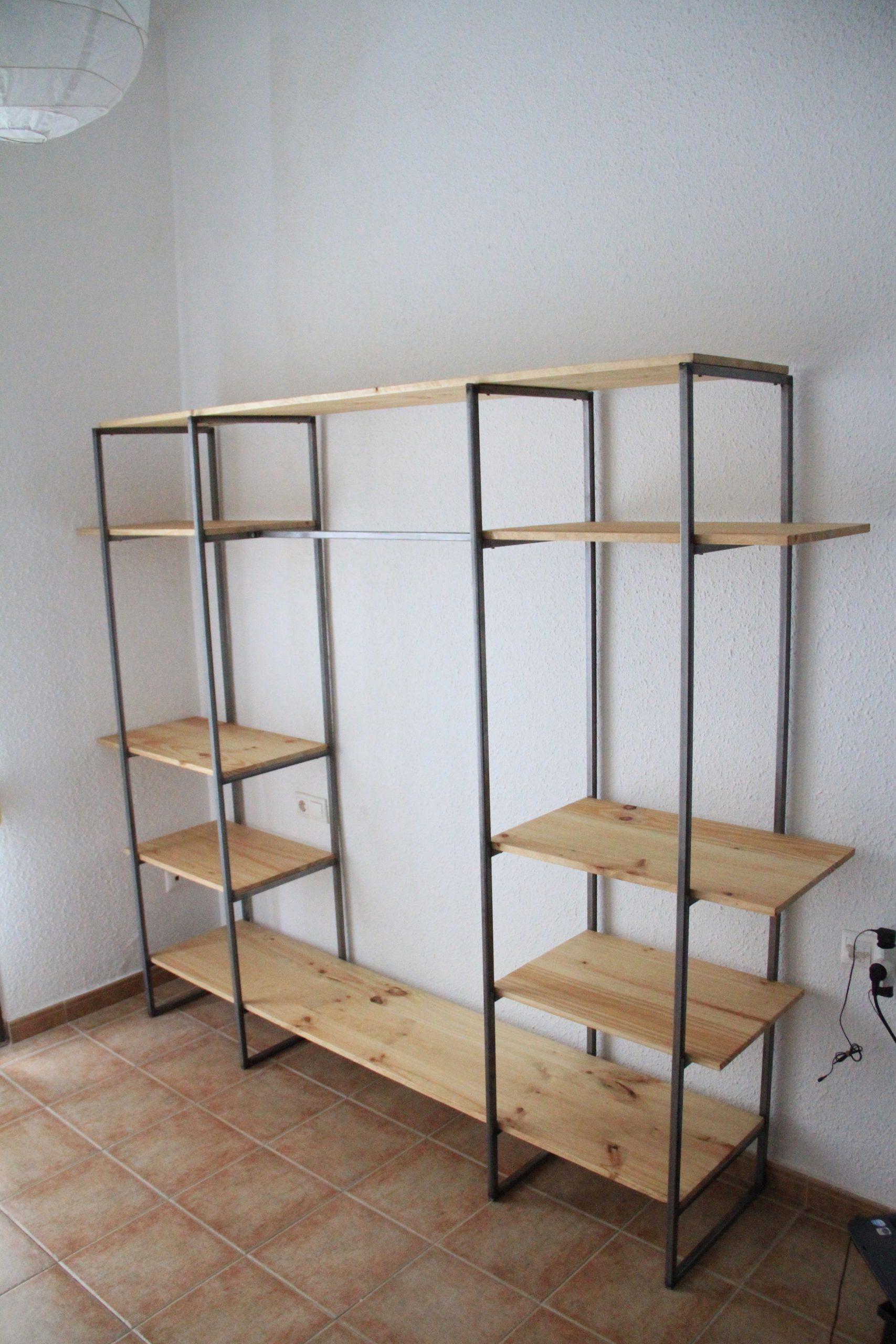 Estantería abierta con baldas de madera y bastidores metálicos.