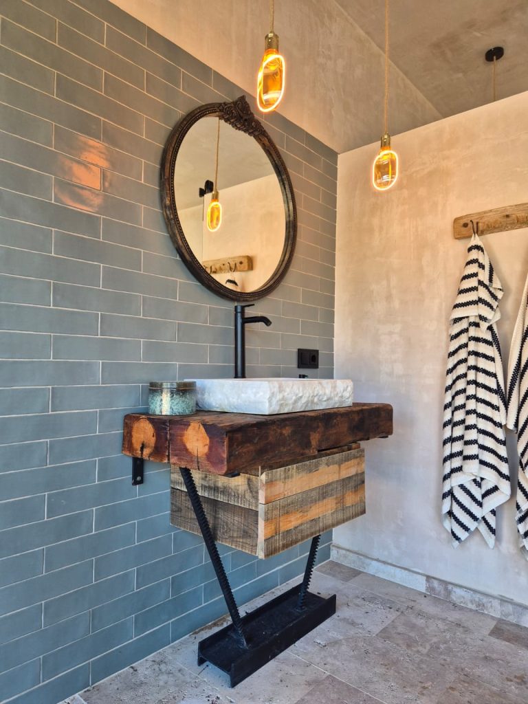 Mueble de lavabo de madera y metal con cajón inferior en un baño.
