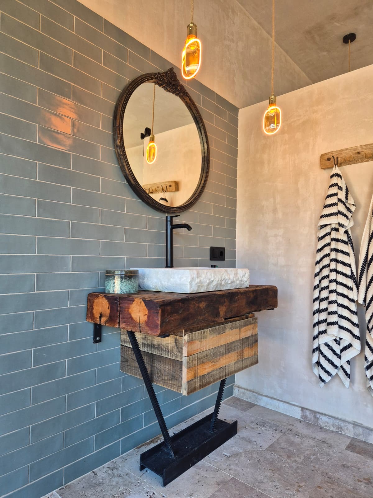 Mueble de lavabo de madera y metal con cajón inferior en un baño.
